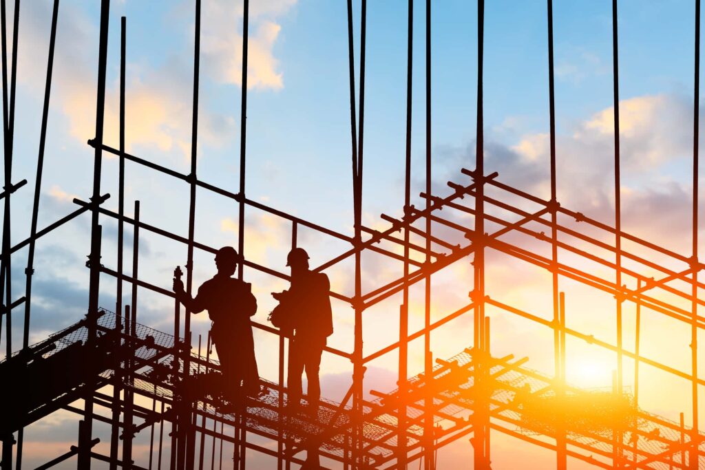 Construction workers standing on scaffolding on building worksite