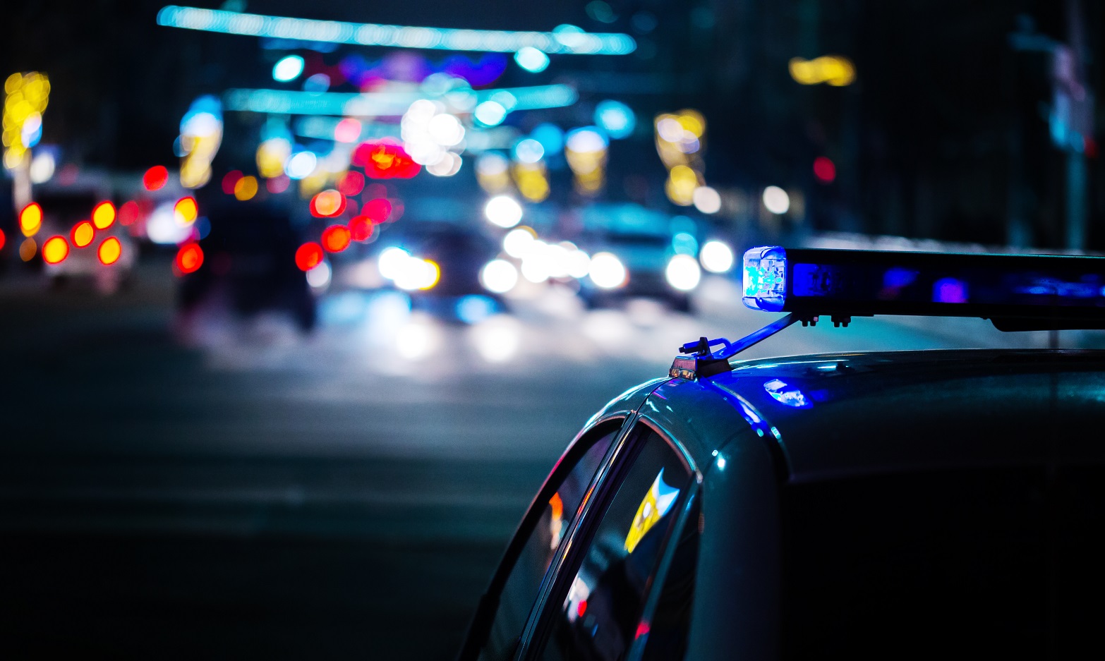 Police car patrolling streets at night to ensure road safety