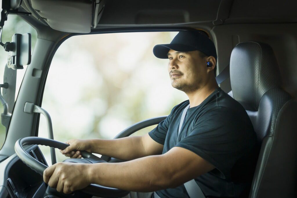 Male truck driver driving transport vehicle for work