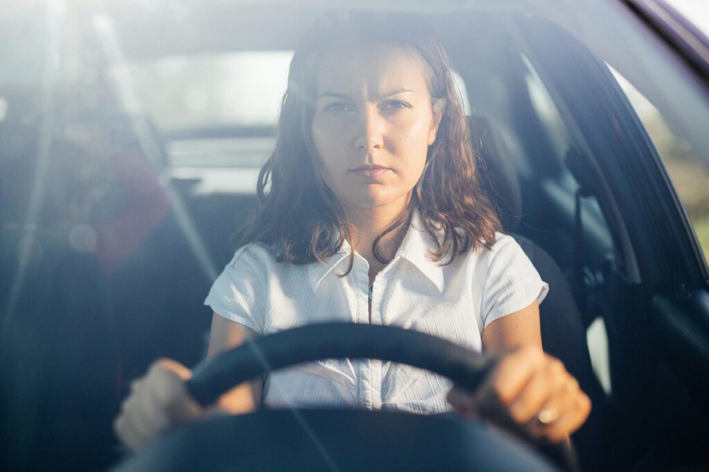 Lady looking serious behind the wheel of a car